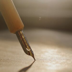 Close-up of a fountain pen tip casting shadow on paper, bathed in warm sunlight.