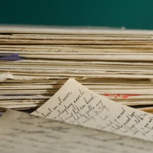 Close-up image of handwritten letters and papers stacked together, conveying a vintage feel.